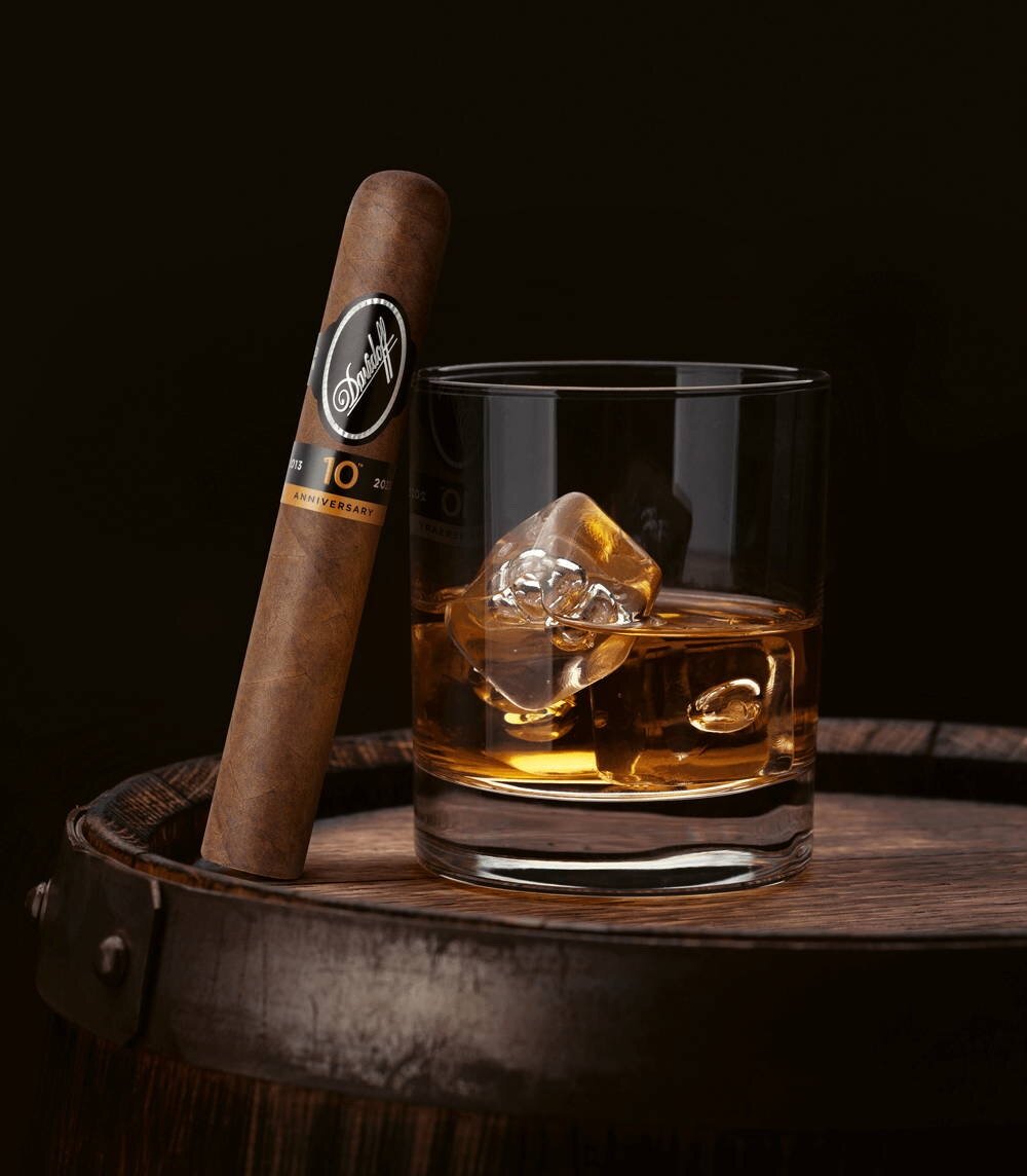 The Davidoff Nicaragua 10th Anniversary Limited Edition gran toro cigar leaning against a glass of rum.