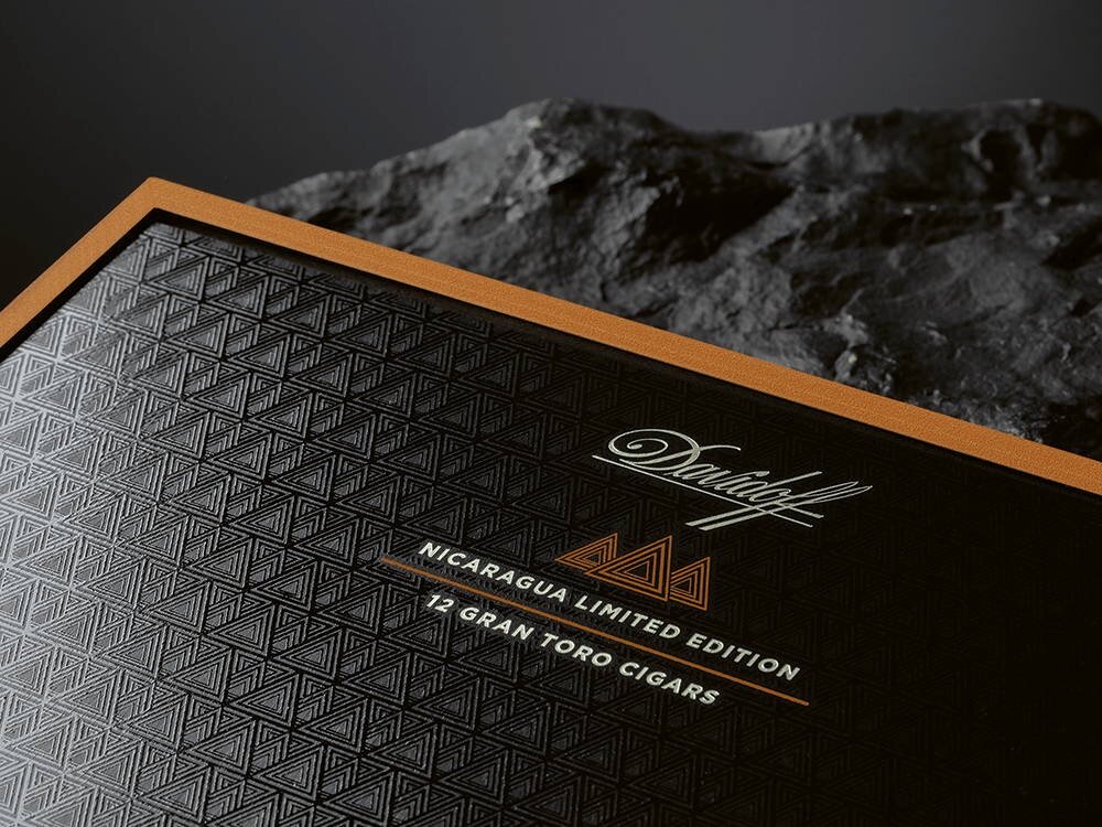 The Davidoff Nicaragua 10th Anniversary Limited Edition wooden box lying on a black rock.