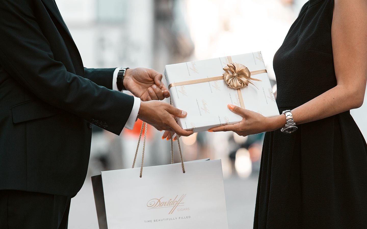 A man presents a Davidoff gift to a woman on the occasion of her graduation. 