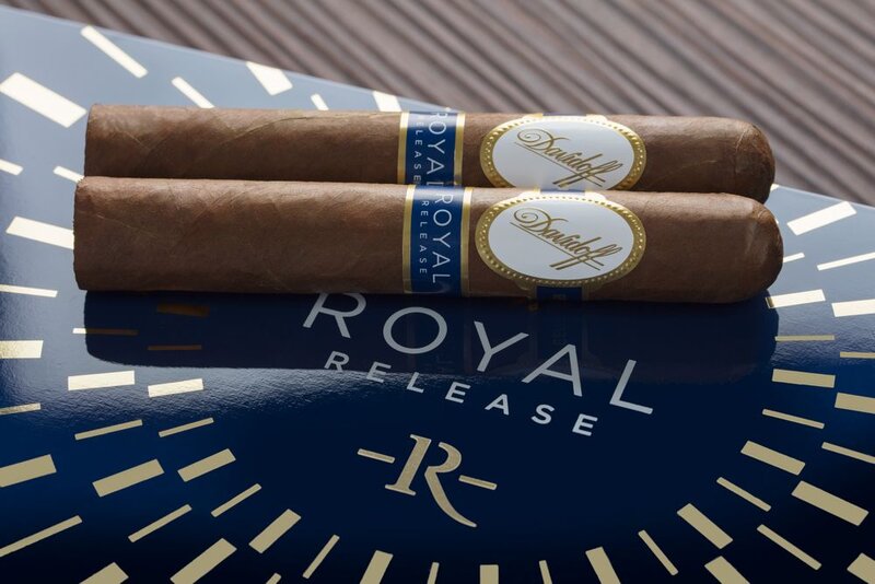 Closeup of two Davidoff Royal Release Robusto cigars on top of its cigar box lid.
