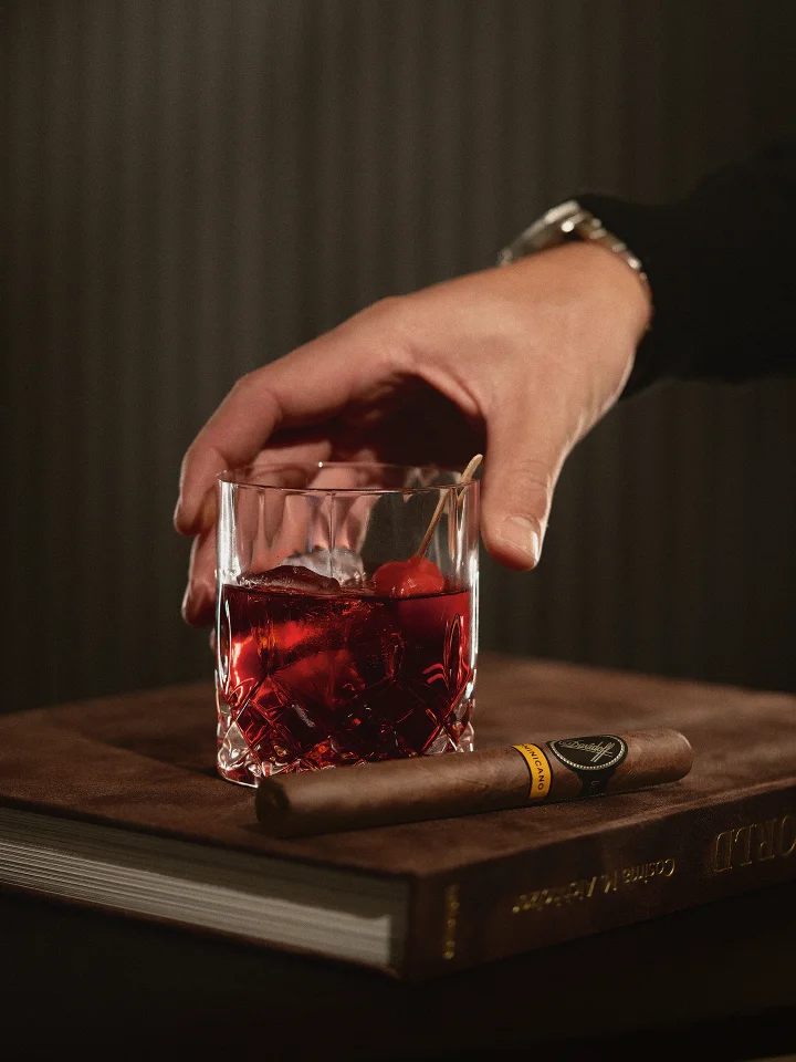 Puro Dominicano cigar leaning against a glass of Velvet ember. 