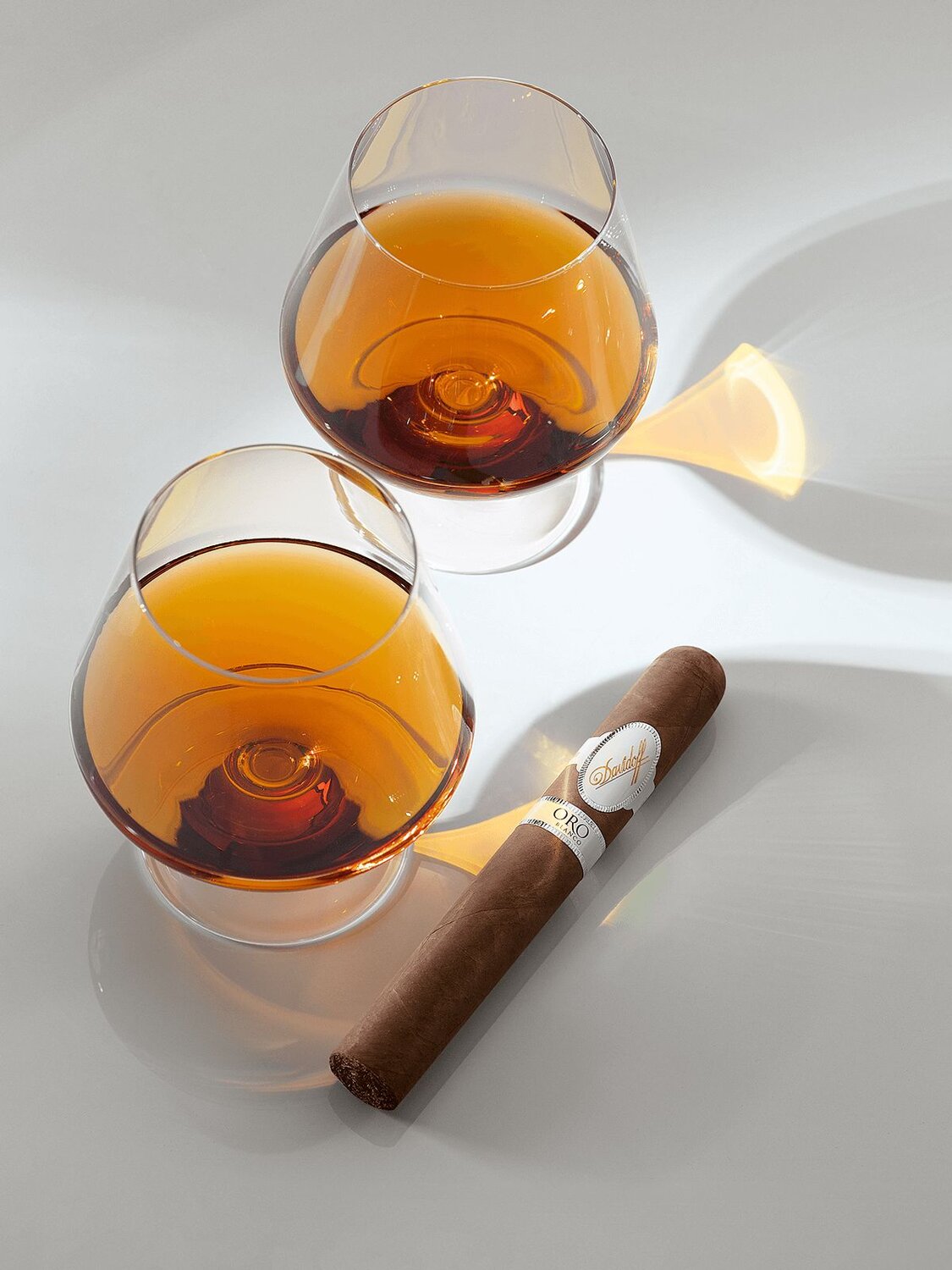 Die Davidoff Oro Blanco Special Reserve 111 neben zwei Gläsern gefüllt mit Cognac.