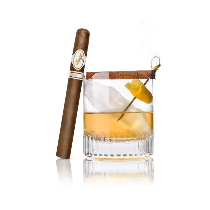 Davidoff Colorado Claro Double R cigar beside a Mezcalo cocktail with ice and lemon twist.