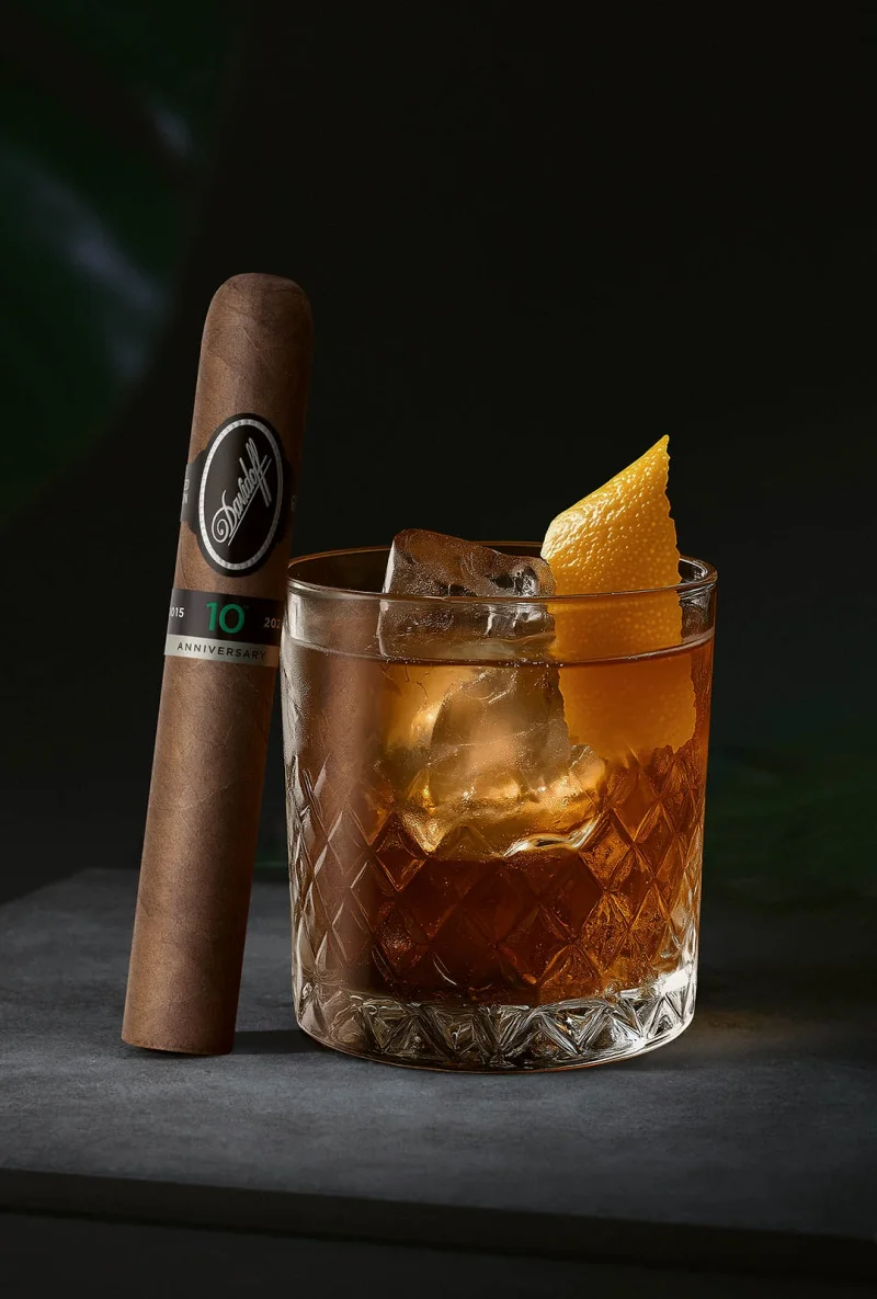 A Davidoff Escurio 10th Anniversary cigar leaning against a Bourbon Old Fashioned.