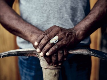 Hands with a Davidoff White Band Ring on the ring finger holding a pickaxe.