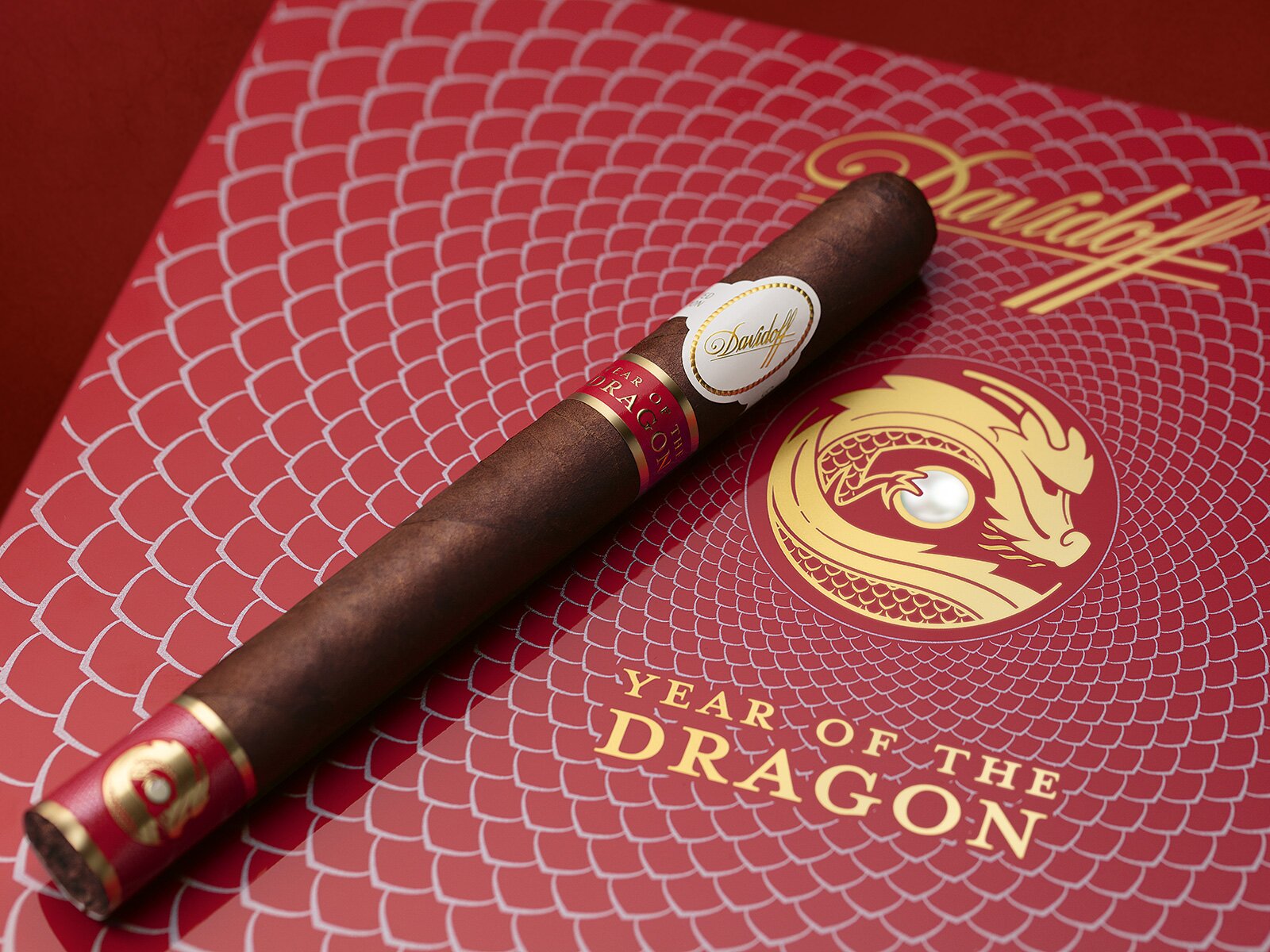 A Davidoff Year of the Dragon Limited Edition double corona cigar placed on the lid of its box.