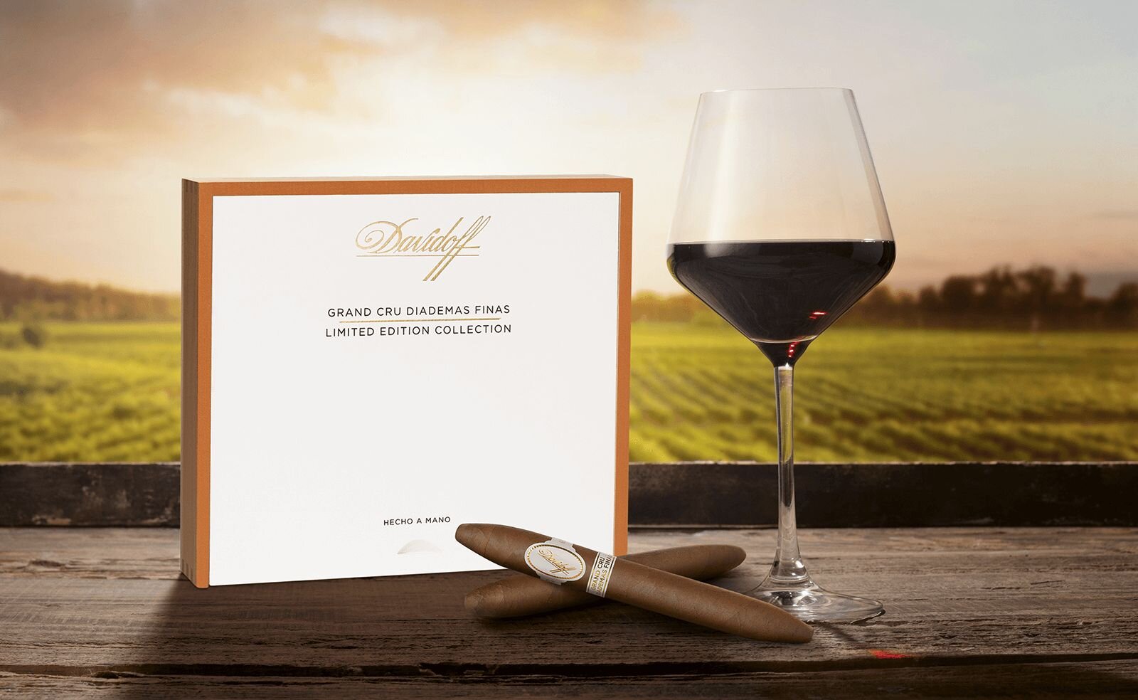 Davidoff Grand Cru Diademas Finas Limited Edition Collection crossed cigars in front of the cigar box with a glass of bordeaux wine next to it.