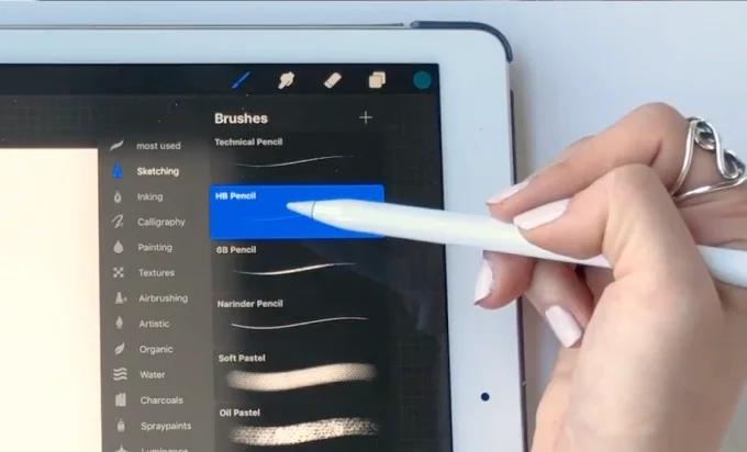 A person draws on a tablet with a pen, showcasing creativity and digital artistry.