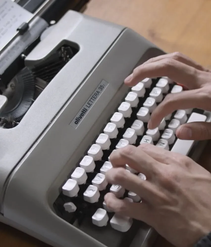 Hands typing on a vintage typewriter, capturing the creative writing process taught in Skillshare classes.
