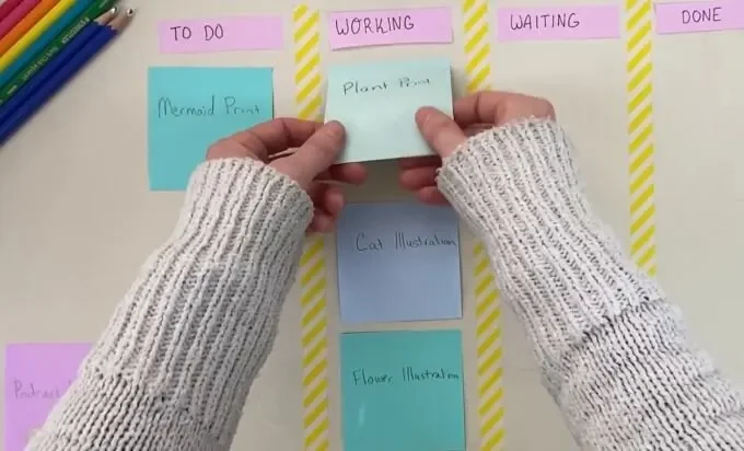A person holds a sticky note on a bulletin board, highlighting important information or reminders.