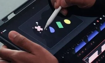 A person drawing on a tablet screen, focused on their artwork with a stylus in hand.