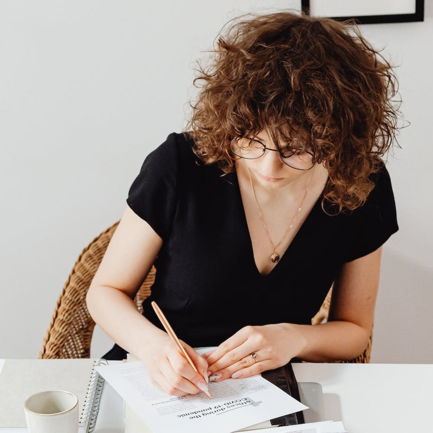 Female therapist sitting at desk using the mental health icd-10 codes cheat sheet