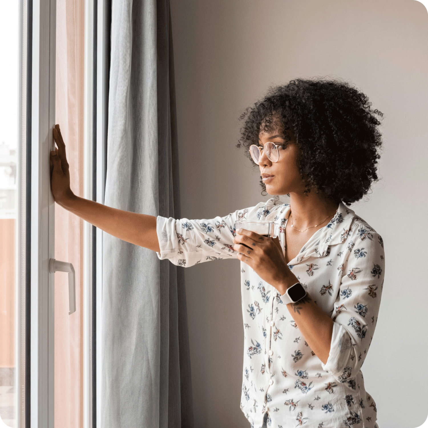 woman looking outside holding a cup and using self-reflection worksheet techniques