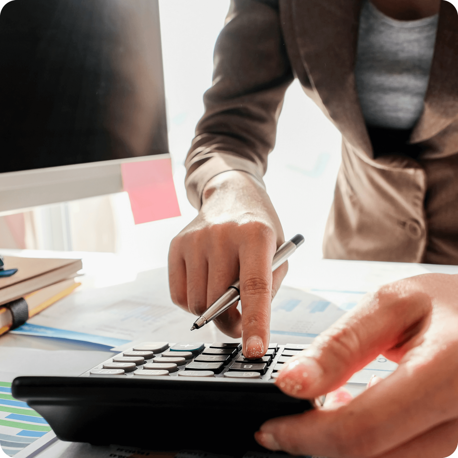 close up of person typing on calculator and working on the financial health of their practice