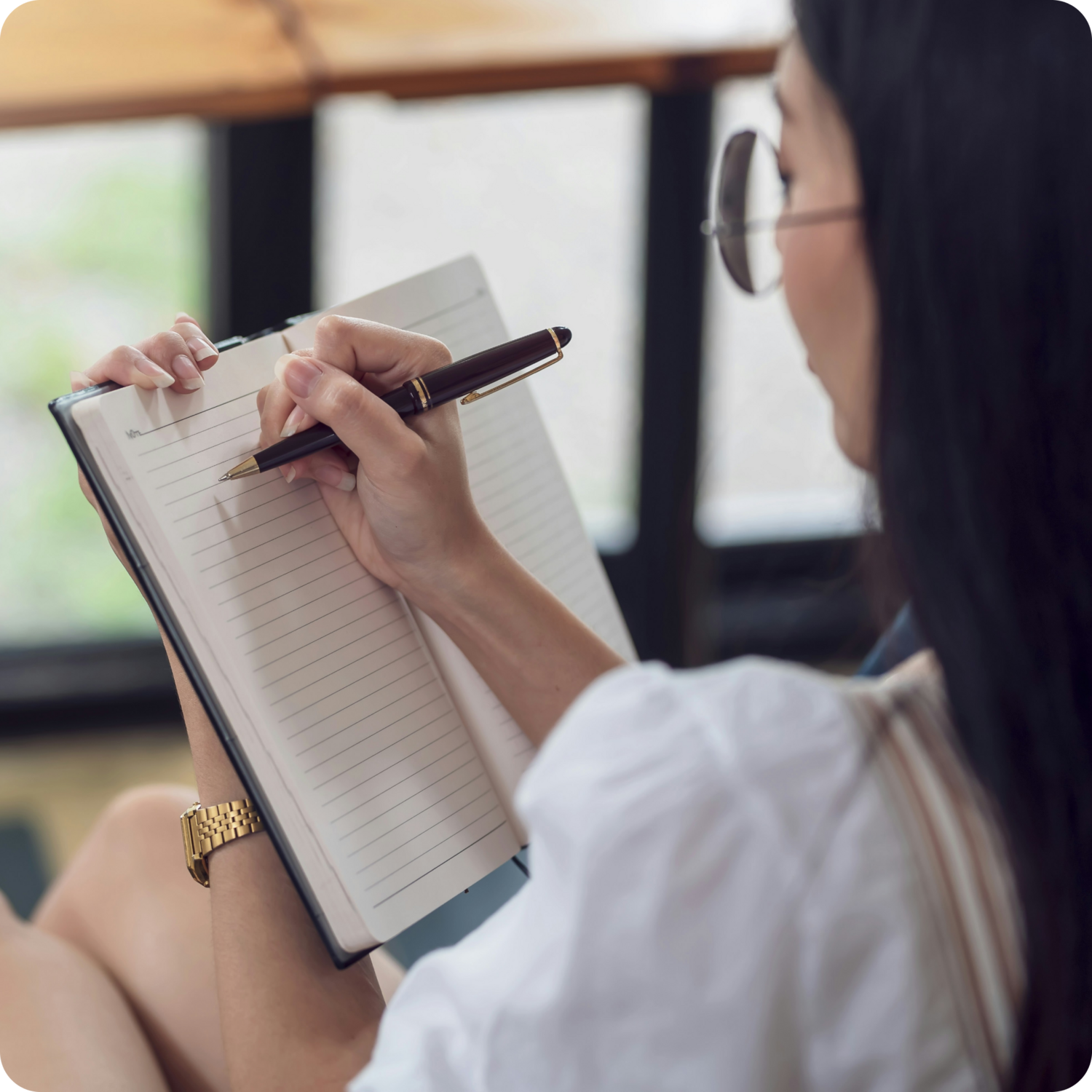 person writing an activity schedule in notebook