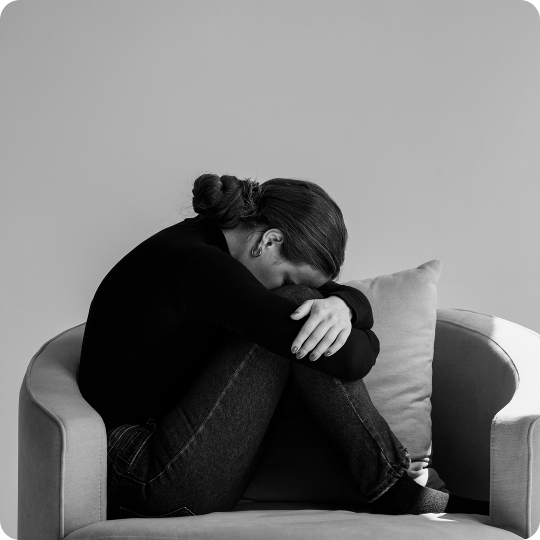 black and white image of woman looking depressed on chair