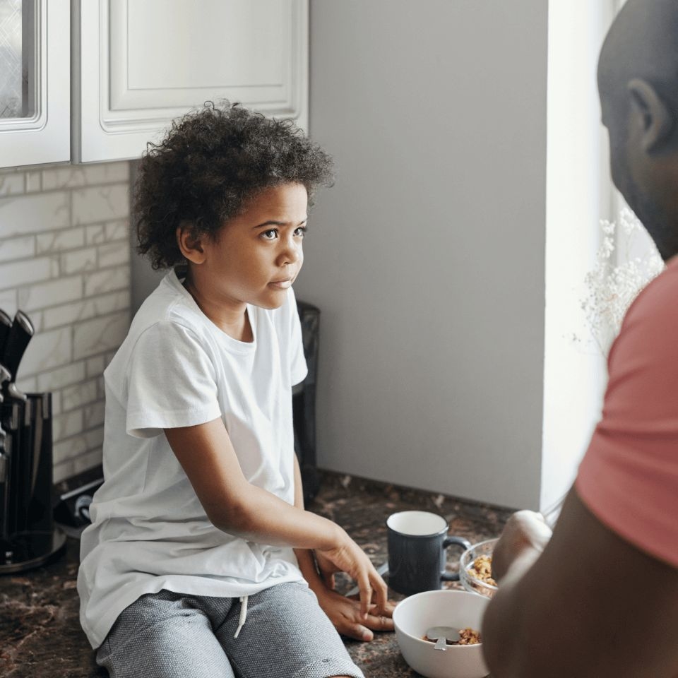 Child sitting on a counter works through tactics found in child anger management worksheets with their father