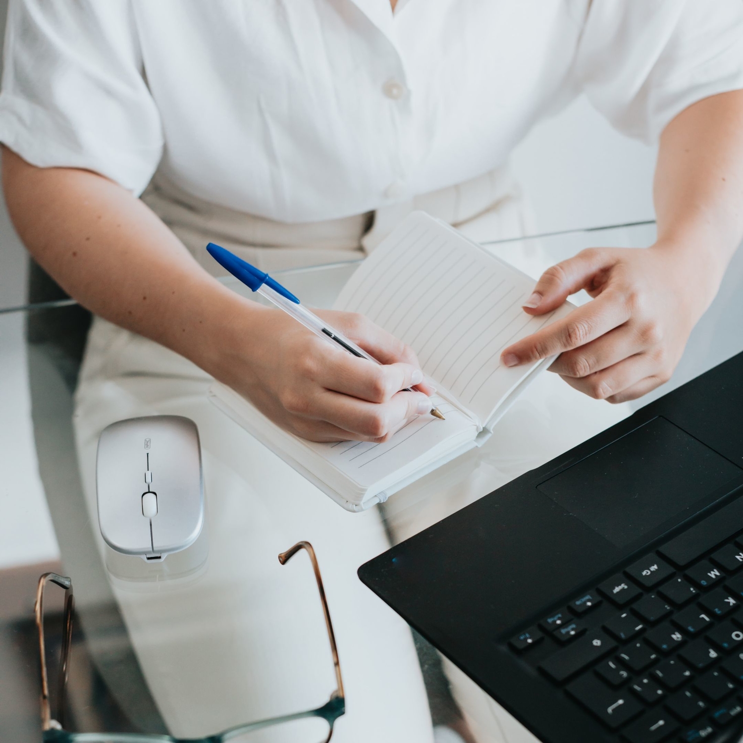 Female clinician writing in notebook the difference between CPT vs. HCPCS codes