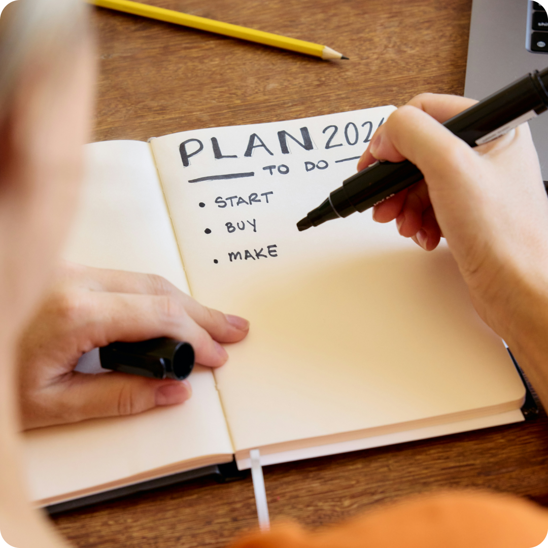 close up of person writing a to do list in a notebook