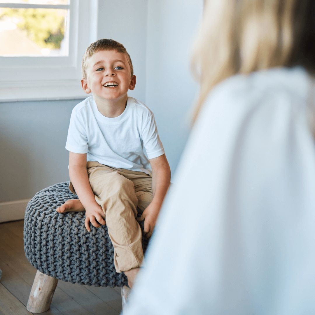 A female clinician uses the ICD-10 code for autistic disorder to diagnose a smiling child during their session