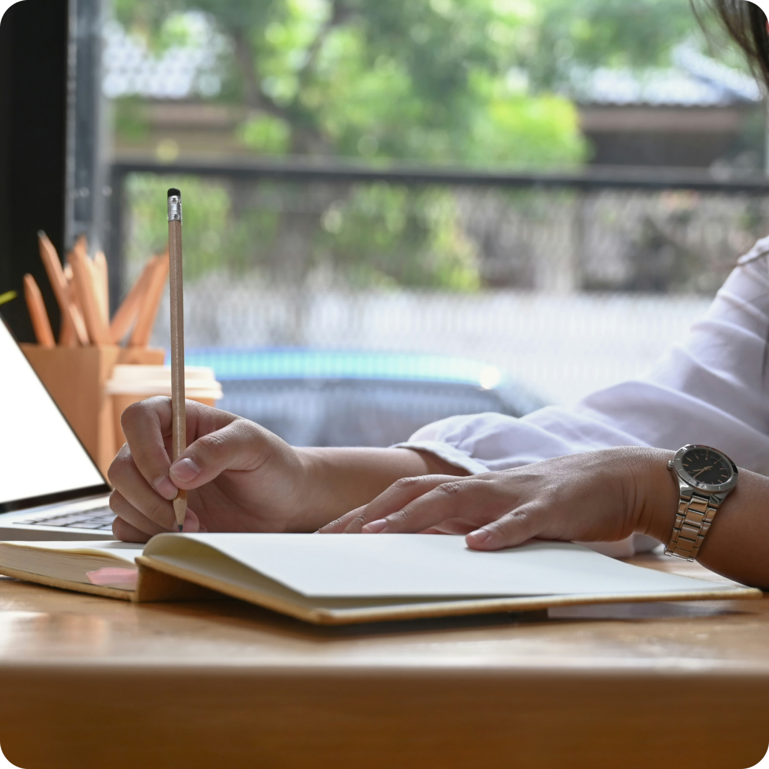 close up of persons hands writing in notebook