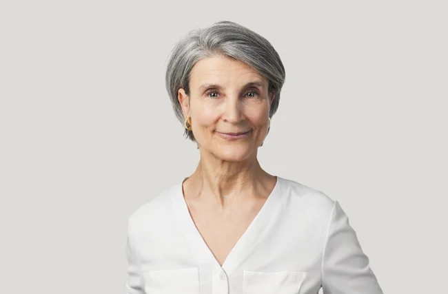 Freundliche Schweizer Ärztin lächelt in die Kamera für Schweizer Männer.