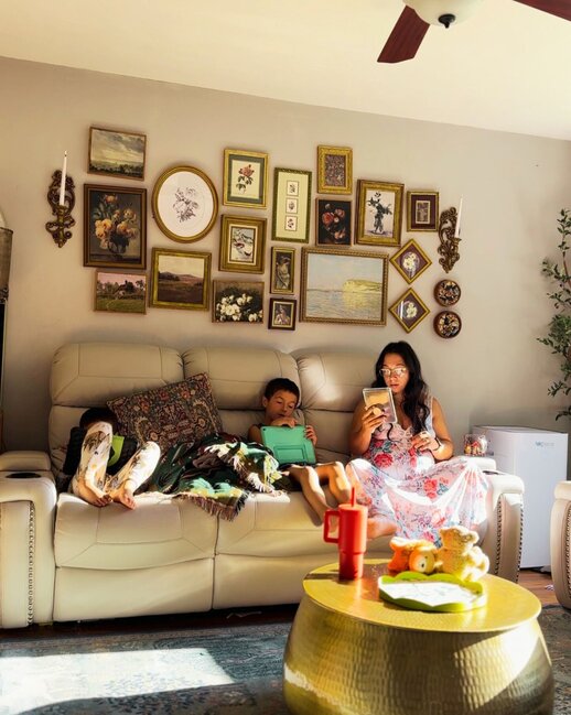 A cozy living room with a family (mother and a children) sitting on a couch, enjoying time together. The AirDoctor purifier is visible in the room: Automatic Air Purifier | AirDoctor 