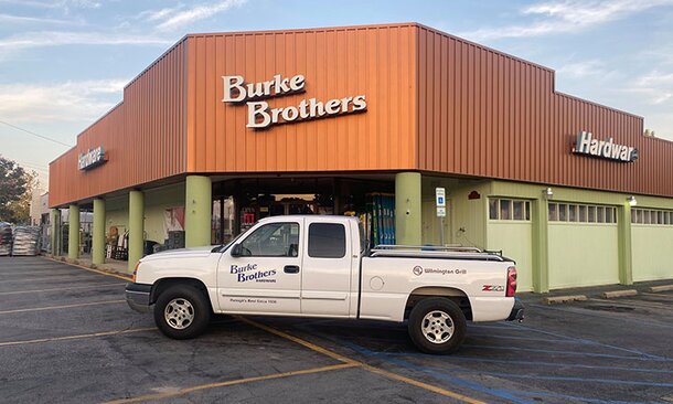 A Burke Brothers delivery truck parked in front of the storefront. 