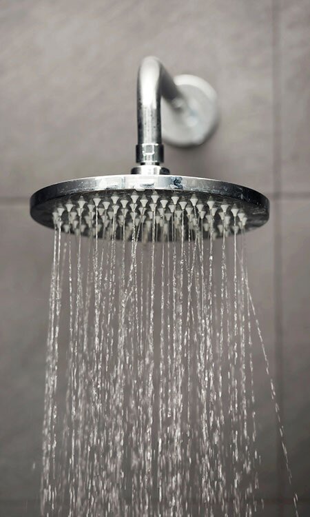 A rainfall-style waterhead turned on in the shower. 