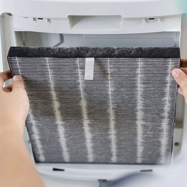 Someone is changing a dirty air filter in a portable unit.