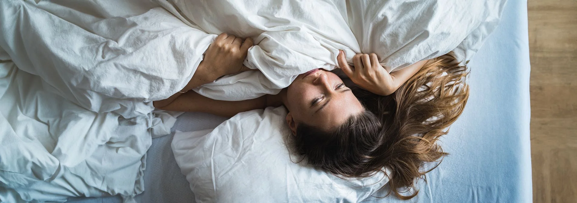 Woman in bed slowly waking up
