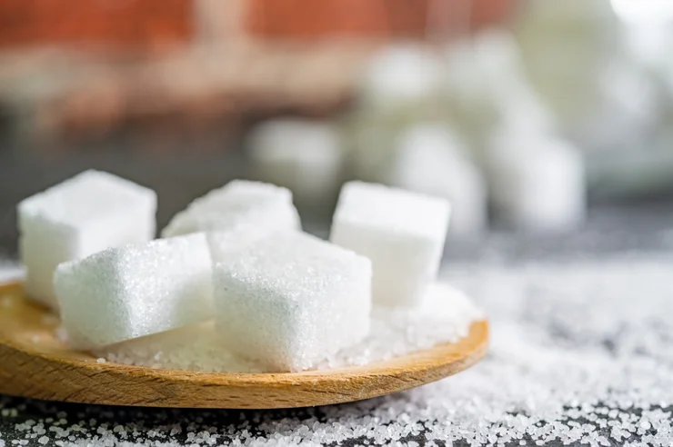 Five cubes of sugar on a wooden spoon