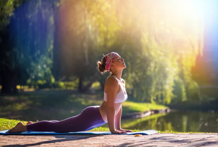 a young woman doing yoga outdoors.