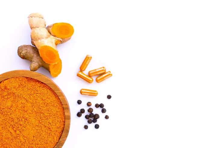 Curcumin powder, Curcuma capsule and black pepper corn isolated on white background. Health benefits and antioxidant food concept.Top view. Flat lay. Selective focus.