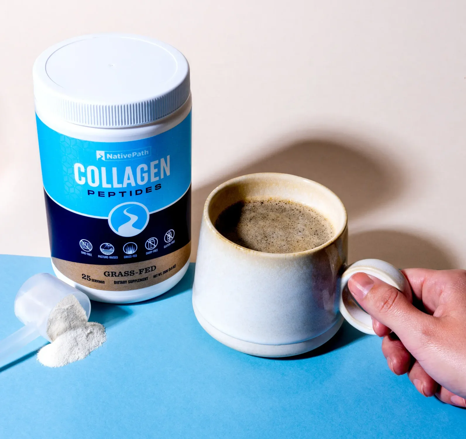 Jar of NativePath Collagen Powder with a Mug of Black Coffee Next to It 