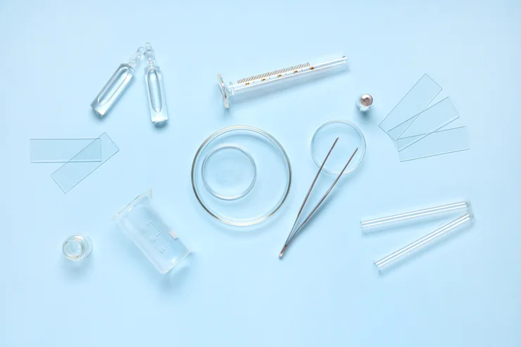 Petri dishes with laboratory equipment on blue background