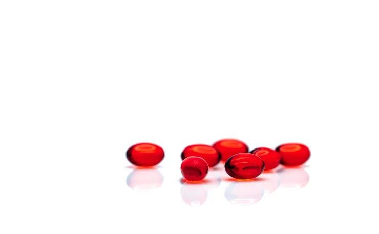 Heart-healthy red krill oil softgels on white background.