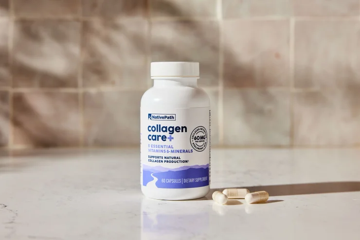 NativePath Collagen Care+ sitting on kitchen countertop with 3 capsules next to bottle.