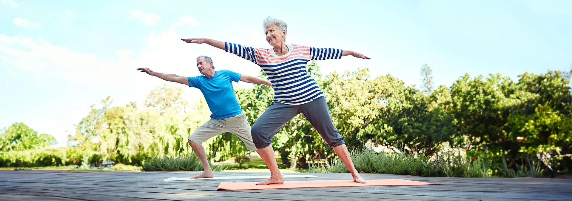 An older couple doing yoga outside