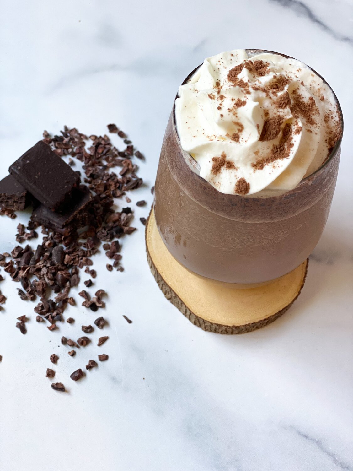 A top view of the Mocha Chip Frappuccino in a clear glass mug on a wooden coaster