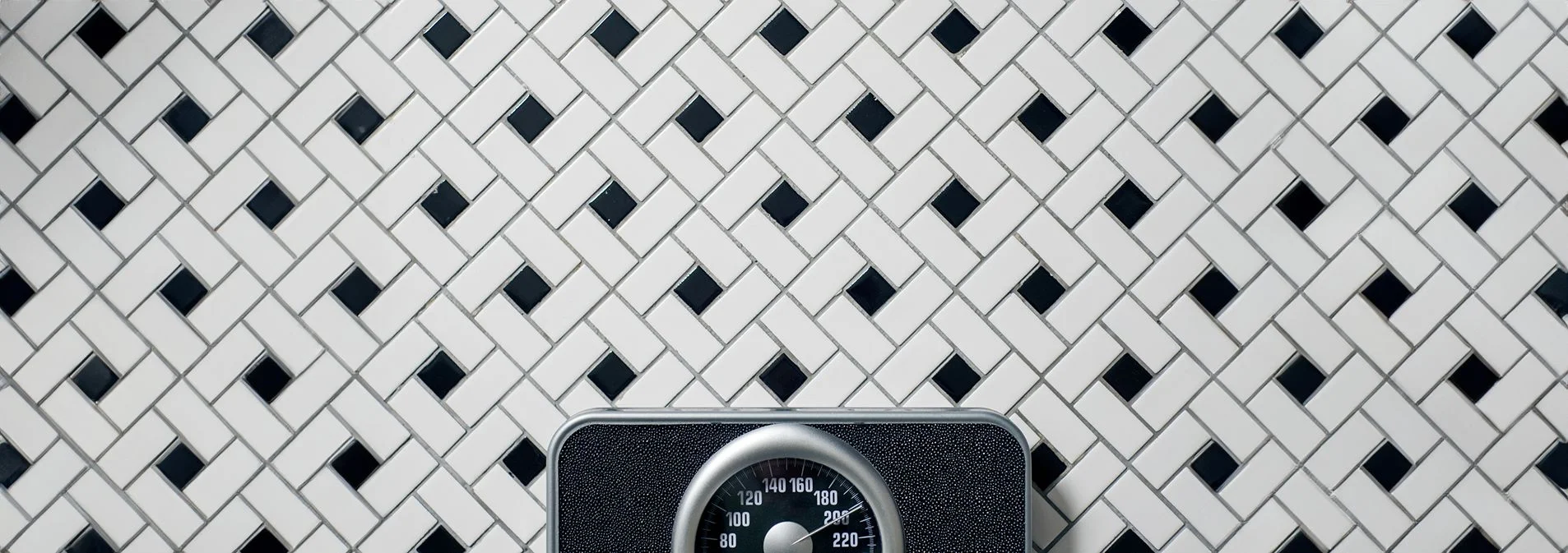 Scale on a black and white tiled floor