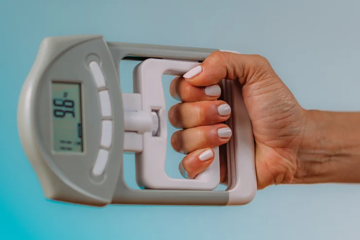 A hand gripping a dynamometer