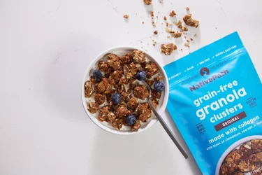 A bowl of NativePath Grain-Free Granola with the bug next to it and a little spilled out of the counter