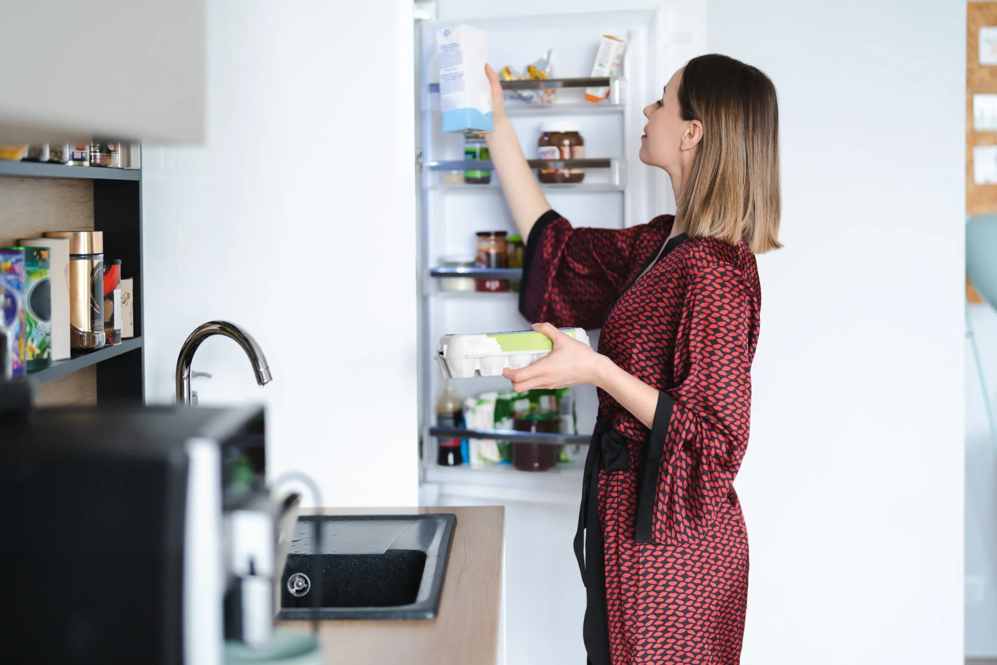 Woman in front of the fridge looking at which of her food and beverage products contain vegetable oil.