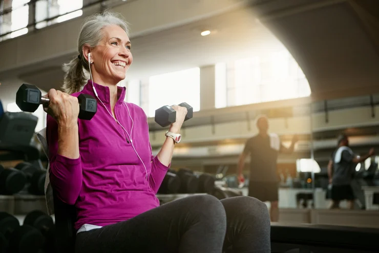 An older woman doing bicep curls with dumbbells