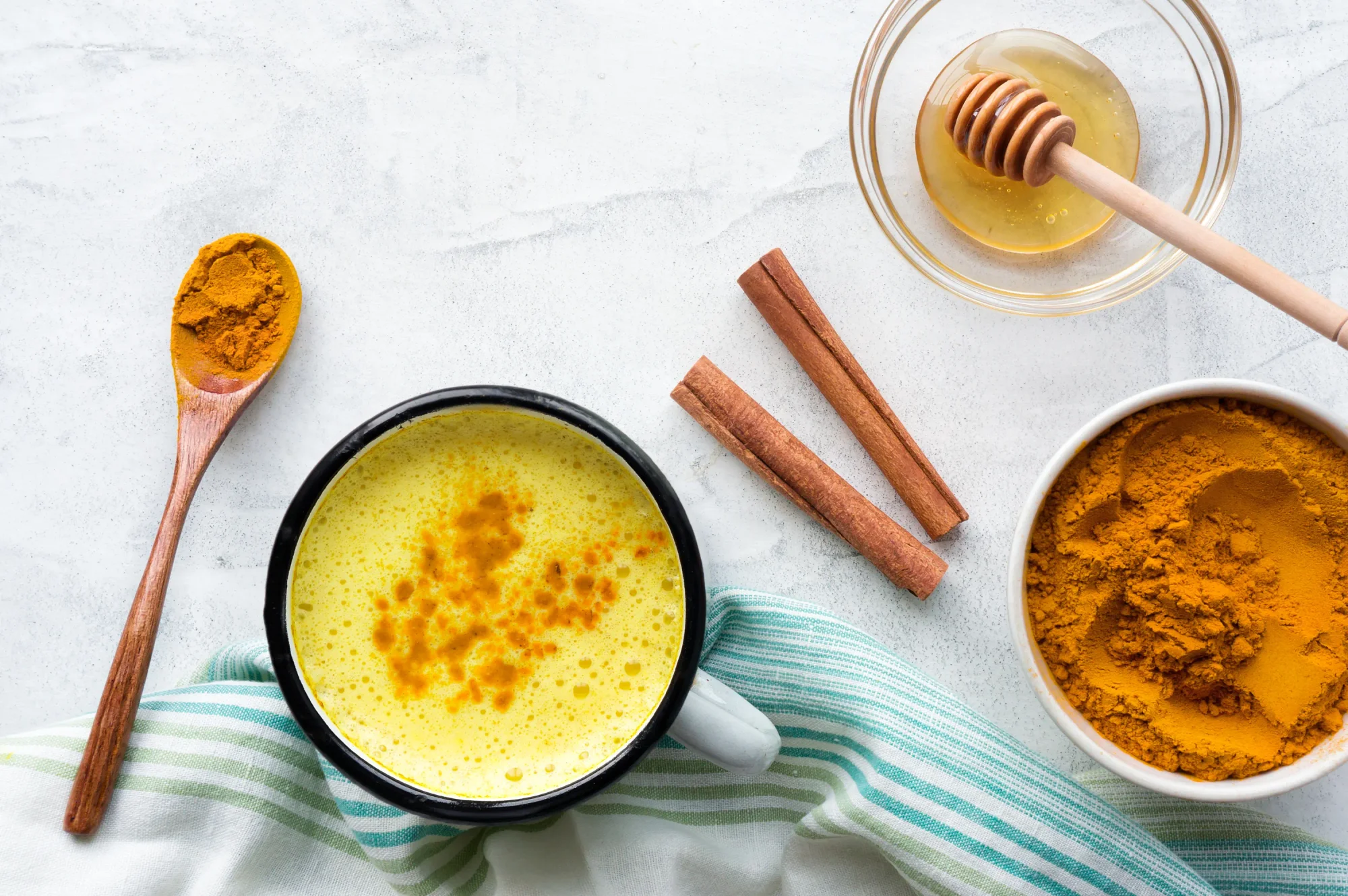 Turmeric latte. Cooking Golden Milk in the kitchen. Hot healthy drink. Top view.