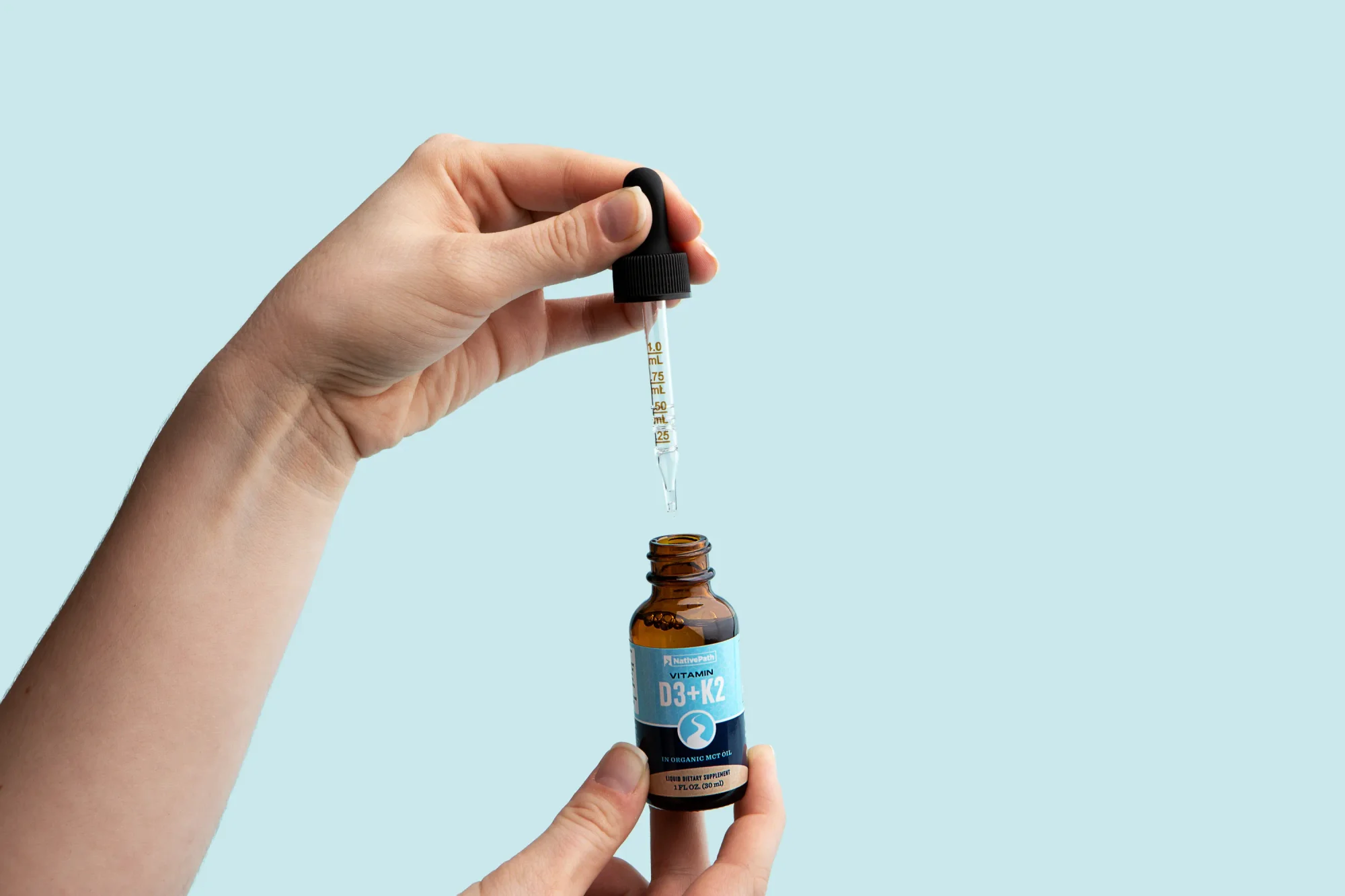 Hand holding NativePath Vitamin D3 + K2 Tincture.