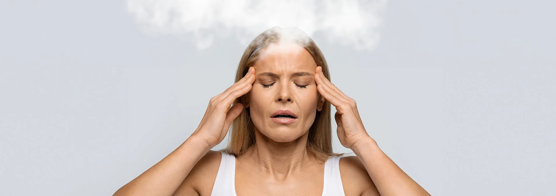 Woman rubbing her temples with smoke coming off of her head.