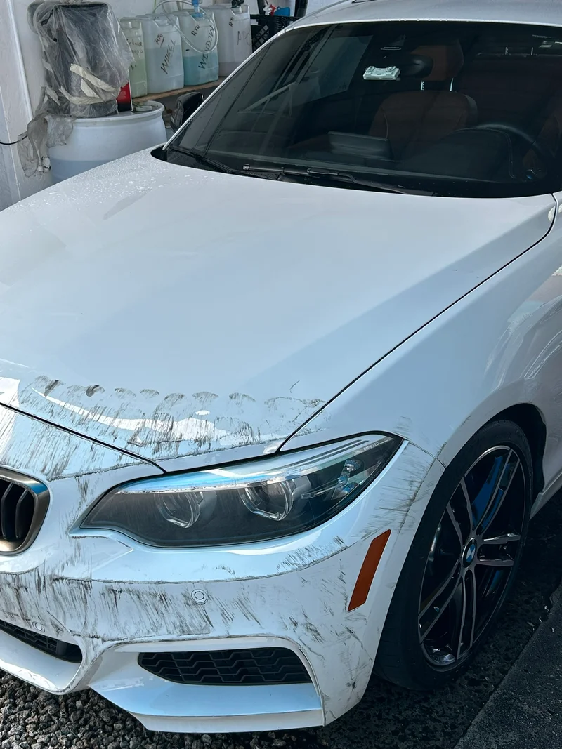 White car hood with swirl marks before paint correction