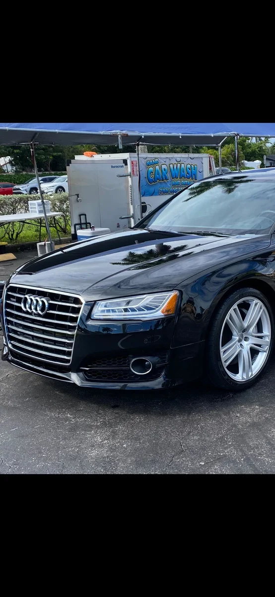 Black Audi sedan beside a car wash canopy